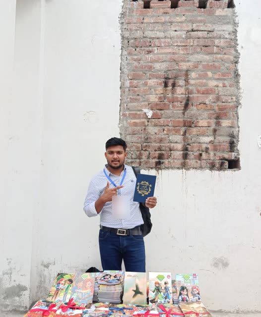 A young volunteer holds up a book beside a table of children's Bible story books